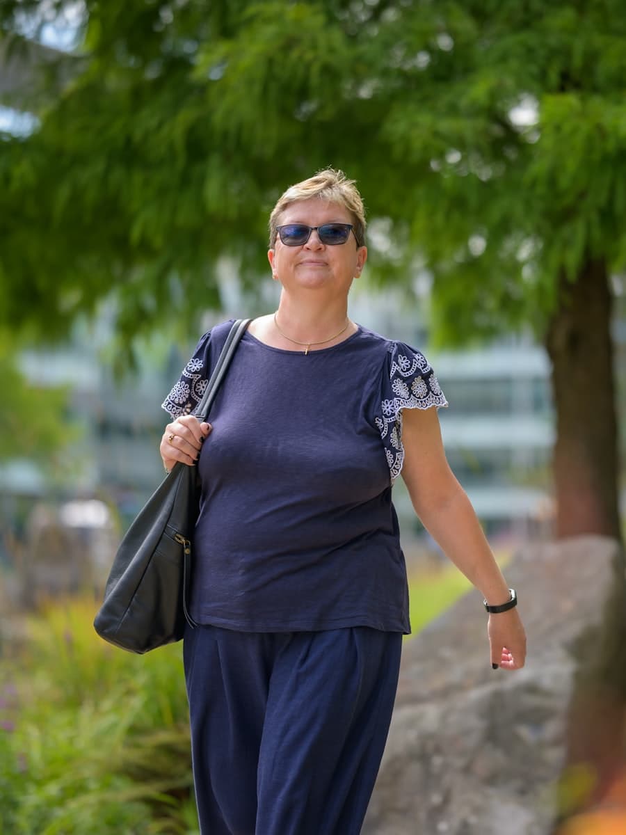 A woman in her late fifties walking through a park on an ordinary weekday morning